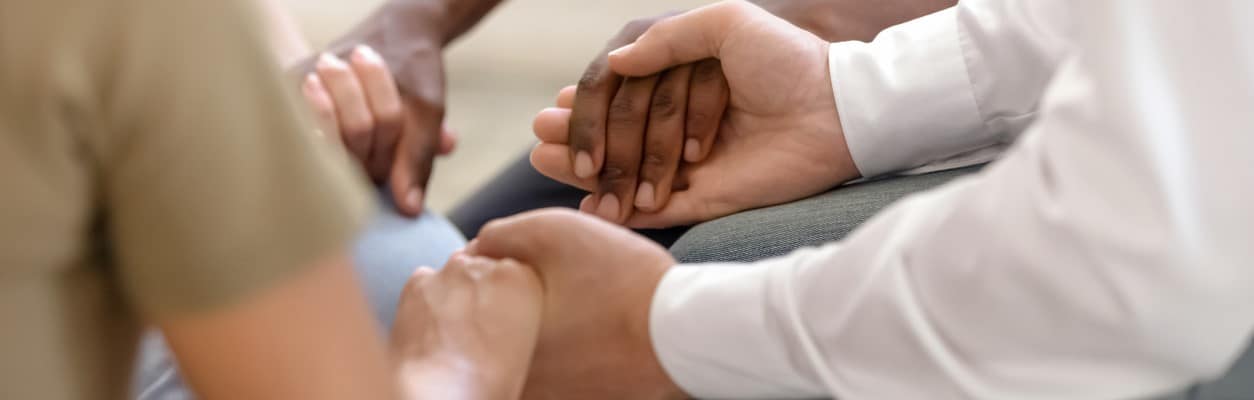 A group of people holding hands during group therapy