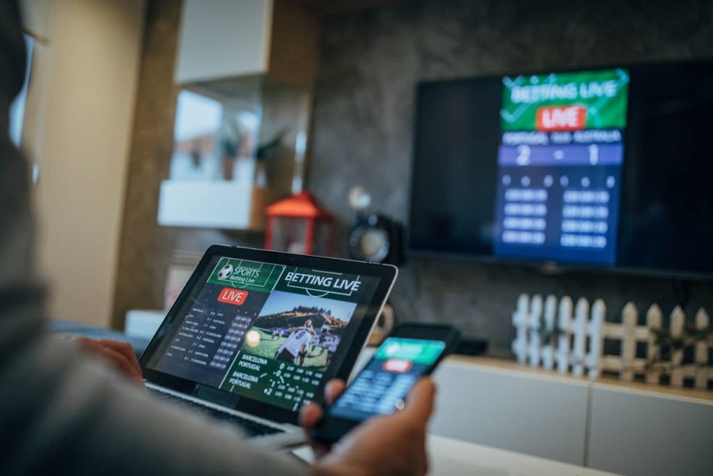 Man watching screen sharing on a tv a sports betting app